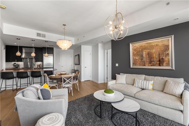 living room featuring a notable chandelier, hardwood / wood-style floors, and sink