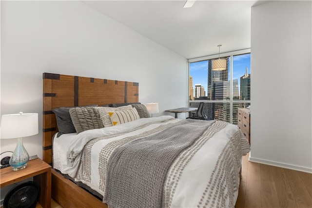 3325 Piedmont Rd NE Unit 2407, Atlanta, GA 30305 - bedroom with a ceiling fan, expansive windows, wood finished floors, baseboards, and a city view