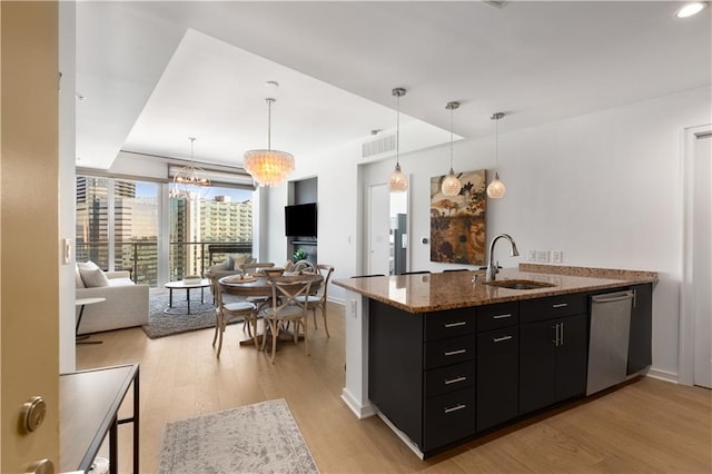 3325 Piedmont Rd NE Unit 2407, Atlanta, GA 30305 - kitchen featuring stainless steel dishwasher, a sink, a peninsula, dark cabinetry, and light wood-style flooring