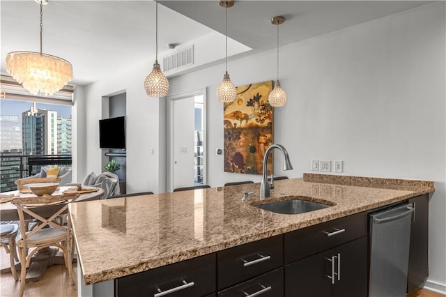 3325 Piedmont Rd NE Unit 2407, Atlanta, GA 30305 - kitchen with light stone countertops, a sink, light wood finished floors, dark cabinets, and visible vents