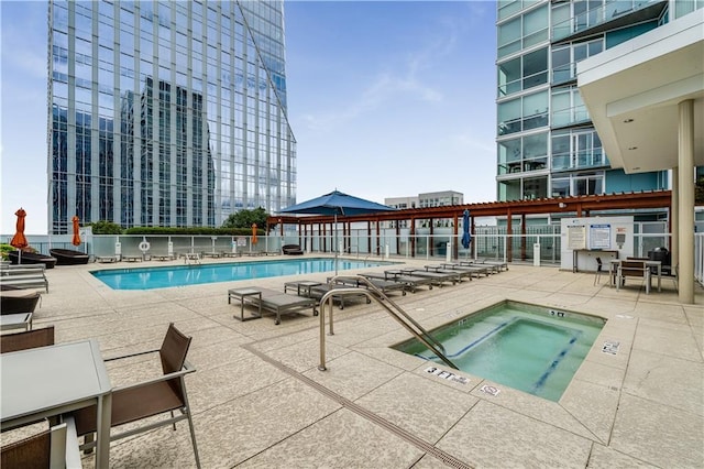 view of swimming pool featuring a hot tub and a patio area