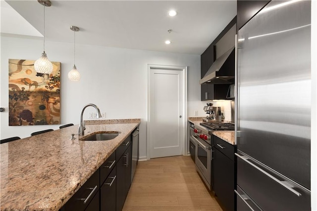 3325 Piedmont Rd NE Unit 2407, Atlanta, GA 30305 - kitchen with high end appliances, wall chimney exhaust hood, dark cabinets, a sink, and light wood finished floors