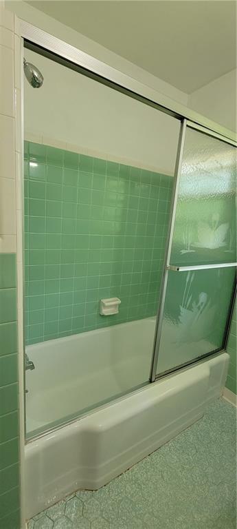 full bath featuring shower / bath combination with glass door