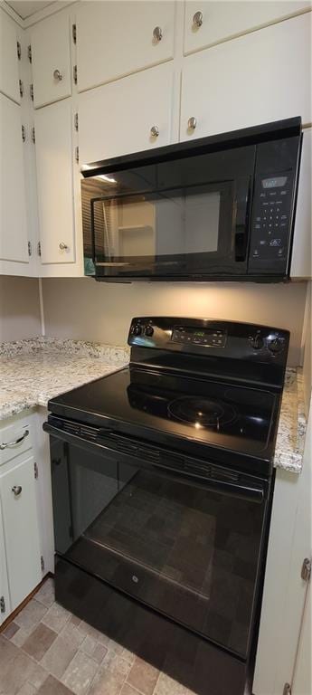kitchen with light countertops, white cabinets, and black appliances