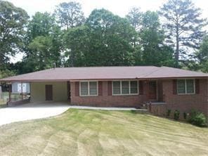 ranch-style house featuring concrete driveway, a front yard, and a carport