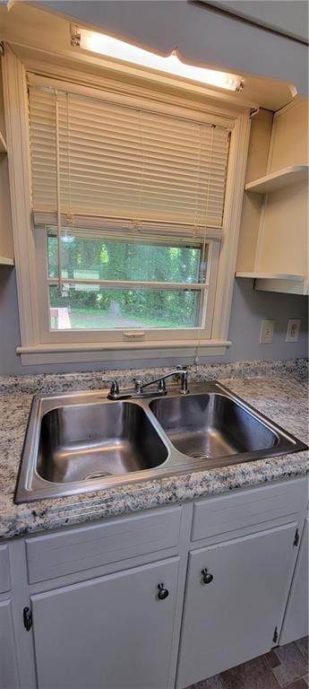 kitchen with a sink, light countertops, plenty of natural light, and white cabinets