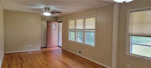 spare room with baseboards, ceiling fan, wood finished floors, and visible vents