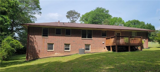 rear view of property with a wooden deck, a yard, central AC unit, and brick siding
