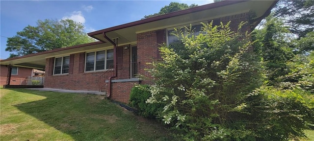 view of side of property featuring a yard and brick siding