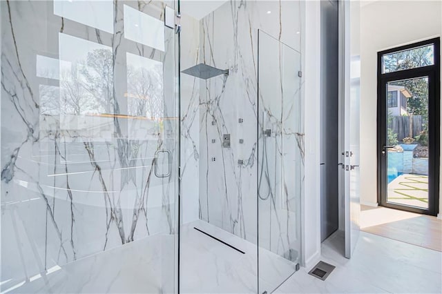 bathroom with a marble finish shower