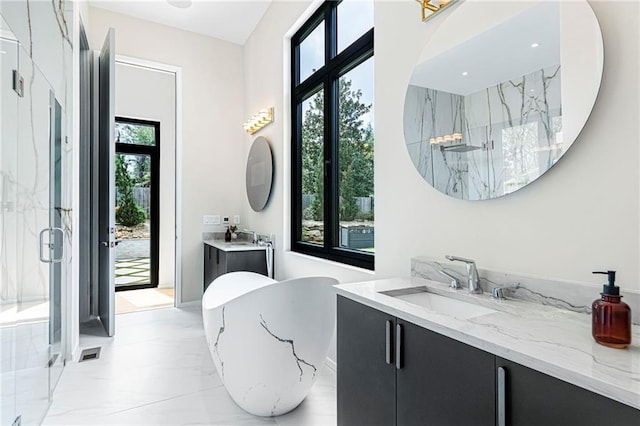 full bath featuring a freestanding tub, a sink, a marble finish shower, two vanities, and marble finish floor