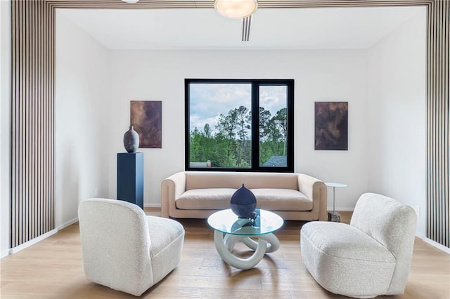 living area featuring baseboards and wood finished floors