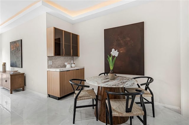dining area featuring marble finish floor and baseboards