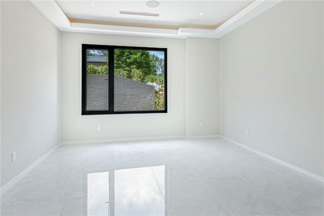 unfurnished room with visible vents, baseboards, and a raised ceiling