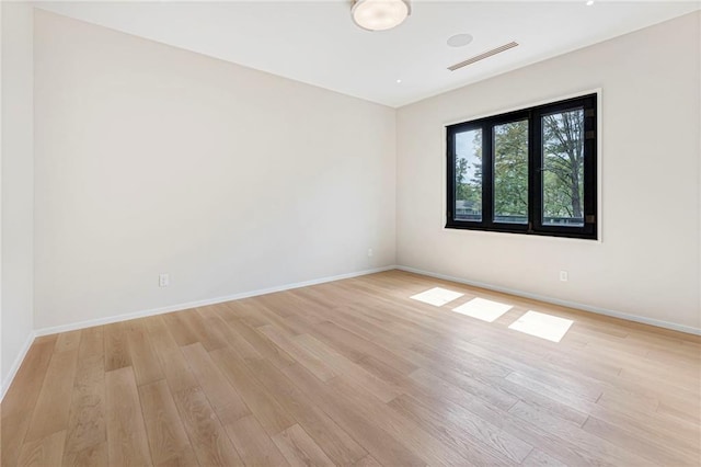 spare room with visible vents, baseboards, and light wood-type flooring