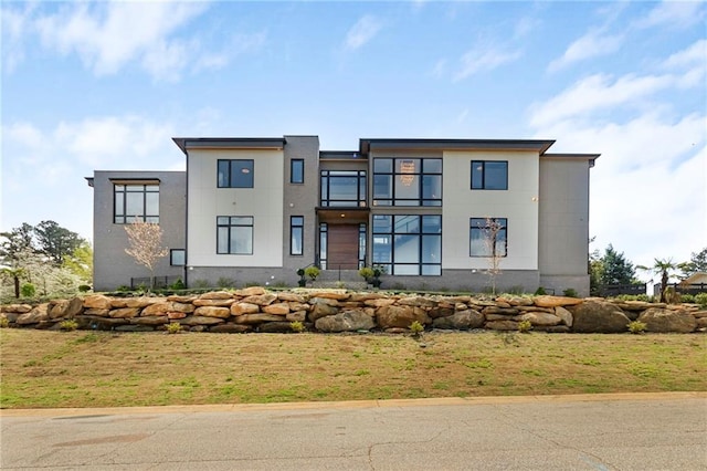 view of front of home with a front yard and stucco siding