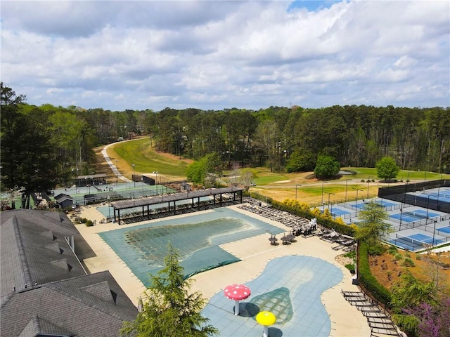 view of swimming pool featuring a forest view