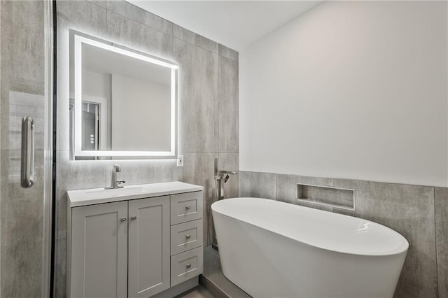 57 Forsyth St NW Unit 14B, Atlanta, GA 30303 - bathroom featuring tile walls, vanity, a freestanding tub, and a shower stall
