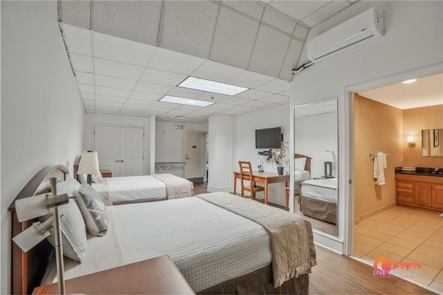 57 Forsyth St NW Unit 14B, Atlanta, GA 30303 - bedroom with a wall mounted air conditioner, baseboards, and ensuite bathroom