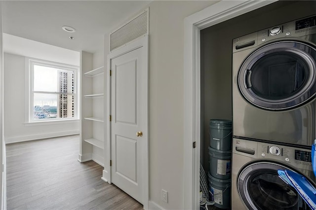 57 Forsyth St NW Unit 14B, Atlanta, GA 30303 - clothes washing area featuring estacked washer and dryer, wood finished floors, and baseboards