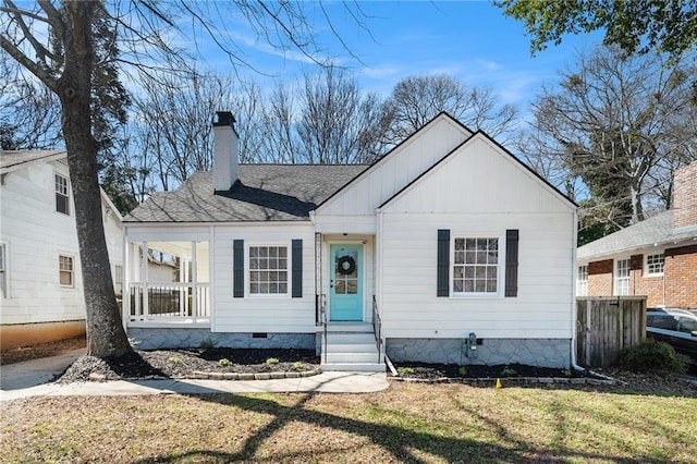 view of front of property with entry steps, a shingled roof, a chimney, crawl space, and a front yard