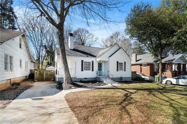 view of front facade featuring a chimney, a shingled roof, crawl space, fence, and a front lawn