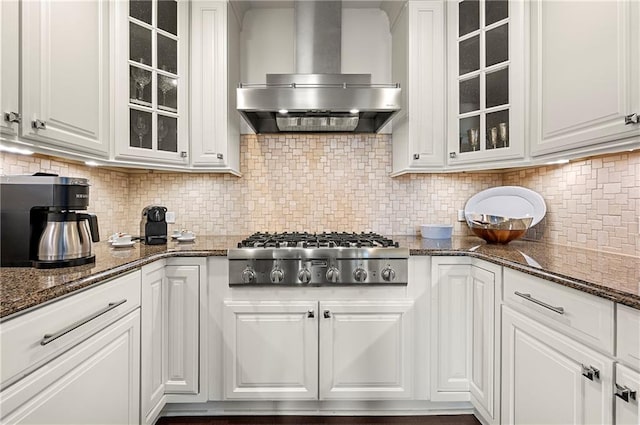 kitchen featuring white cabinetry, wall chimney range hood, tasteful backsplash, and stainless steel gas stovetop