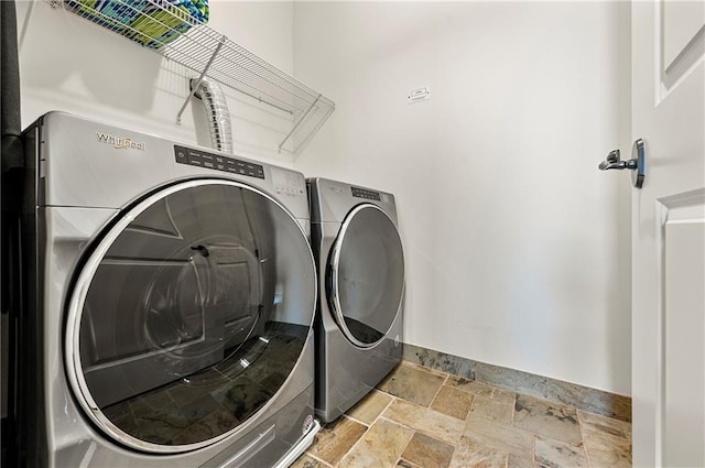 laundry room featuring washer and dryer, laundry area, and stone tile flooring