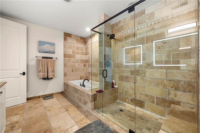 bathroom featuring stone tile floors, a shower stall, baseboards, and a garden tub