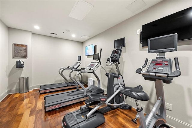 exercise room featuring recessed lighting, visible vents, baseboards, and wood finished floors