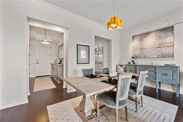 dining room featuring dark wood-style floors, an inviting chandelier, baseboards, and ornamental molding