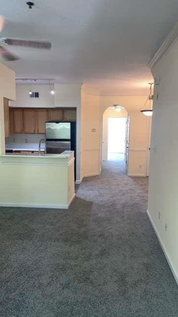 kitchen featuring sink, stainless steel fridge, ornamental molding, ceiling fan, and dark carpet