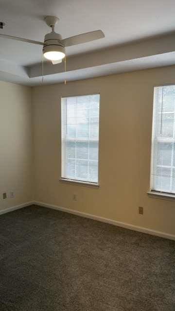 carpeted empty room featuring ceiling fan