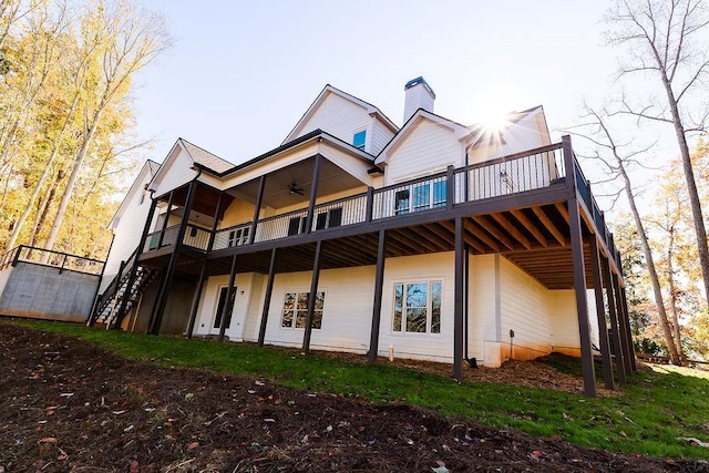 rear view of property with a deck, a chimney, ceiling fan, and stairs