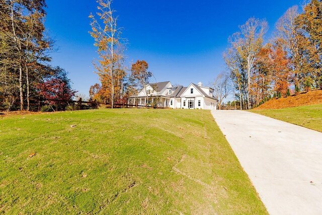 view of front of property featuring concrete driveway and a front lawn