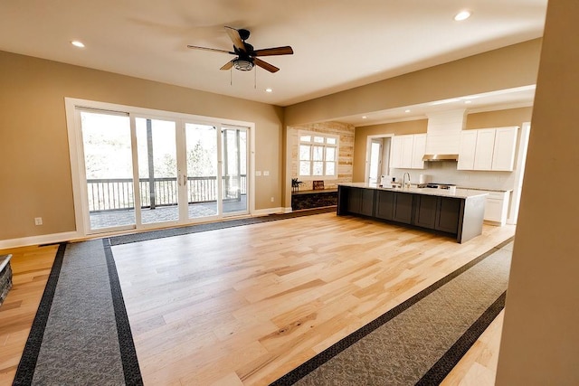 kitchen with baseboards, light wood-style flooring, and white cabinetry