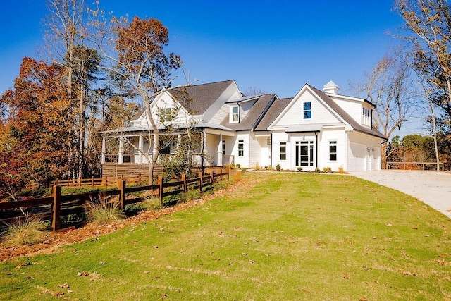 view of front of property featuring a front lawn, fence, concrete driveway, a chimney, and a garage