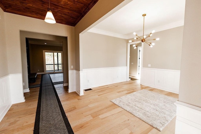 unfurnished dining area featuring visible vents, crown molding, light wood-style floors, wooden ceiling, and a notable chandelier