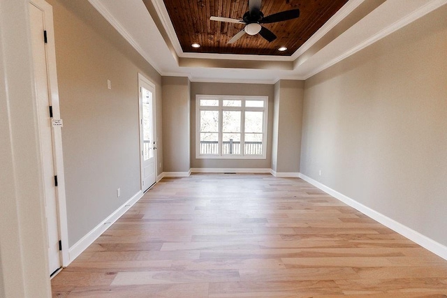 unfurnished room featuring a ceiling fan, a tray ceiling, crown molding, and wood ceiling