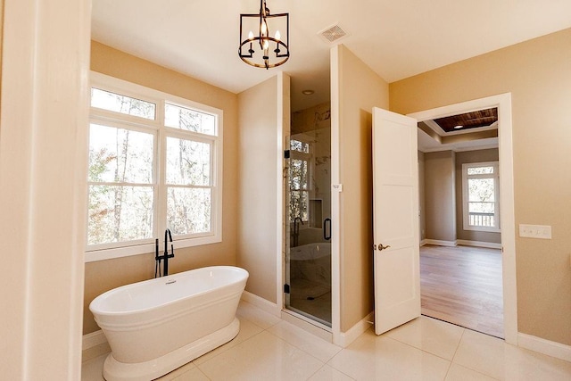 full bath with visible vents, a soaking tub, a shower stall, tile patterned floors, and a chandelier