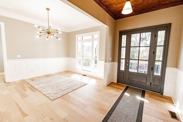 foyer entrance featuring visible vents, wood ceiling, an inviting chandelier, and ornamental molding