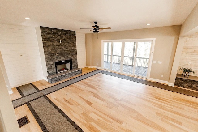 unfurnished living room with a fireplace, baseboards, a ceiling fan, and wood finished floors