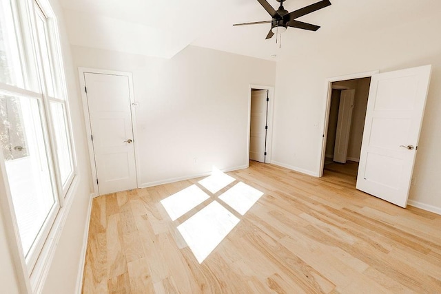 unfurnished bedroom featuring ceiling fan, baseboards, and light wood-style floors