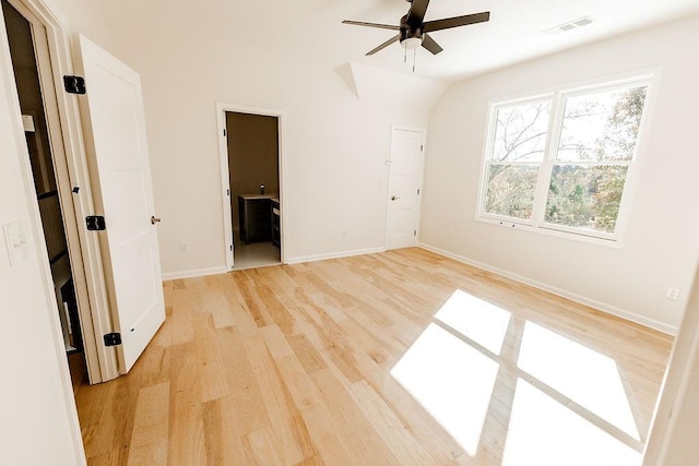 unfurnished bedroom with visible vents, baseboards, light wood-type flooring, lofted ceiling, and ensuite bathroom