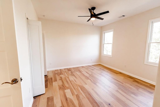 spare room with baseboards, a healthy amount of sunlight, visible vents, and light wood-type flooring