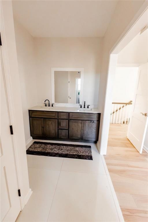 full bath with double vanity, baseboards, and a sink