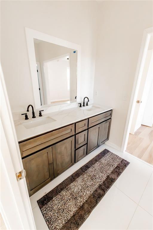 bathroom featuring a sink, double vanity, and tile patterned floors