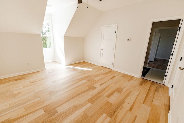 bonus room with baseboards, vaulted ceiling, a ceiling fan, and light wood finished floors