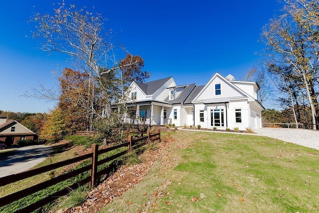 view of front facade featuring a front lawn, fence, a garage, and driveway