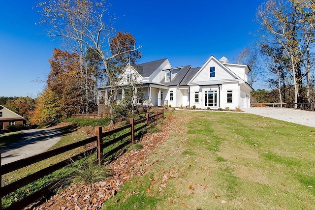 view of front facade with a front yard, driveway, and fence